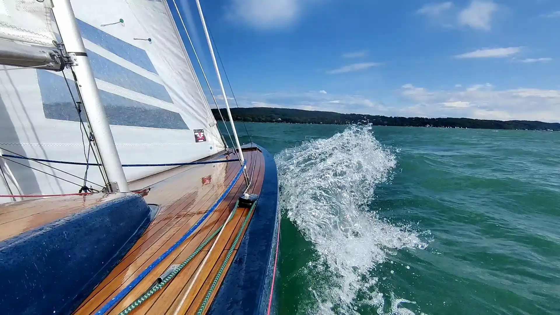 Segelyacht unter Segeln auf dem Starnberger See, Gischt am Bug