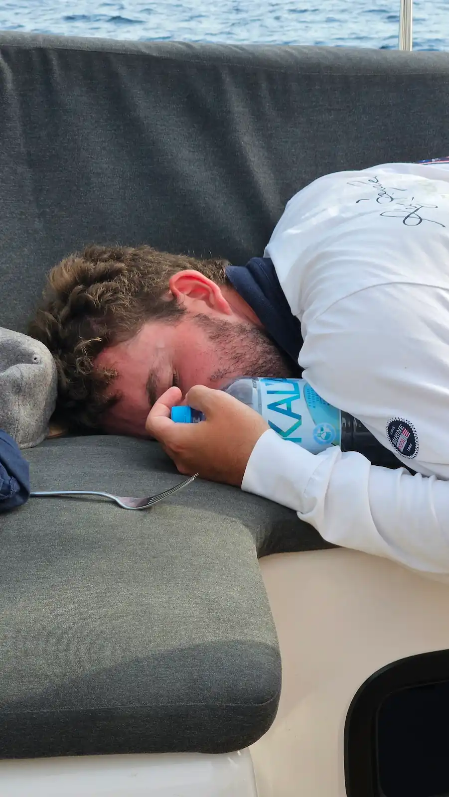 Moritz macht einen Powernap im Cockpit einer Segelyacht auf dem Meer